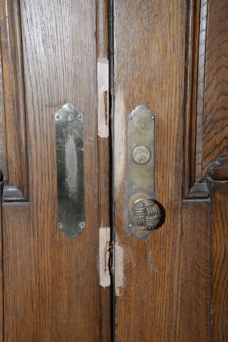 Brass lock furniture on a timber door in a humid interior