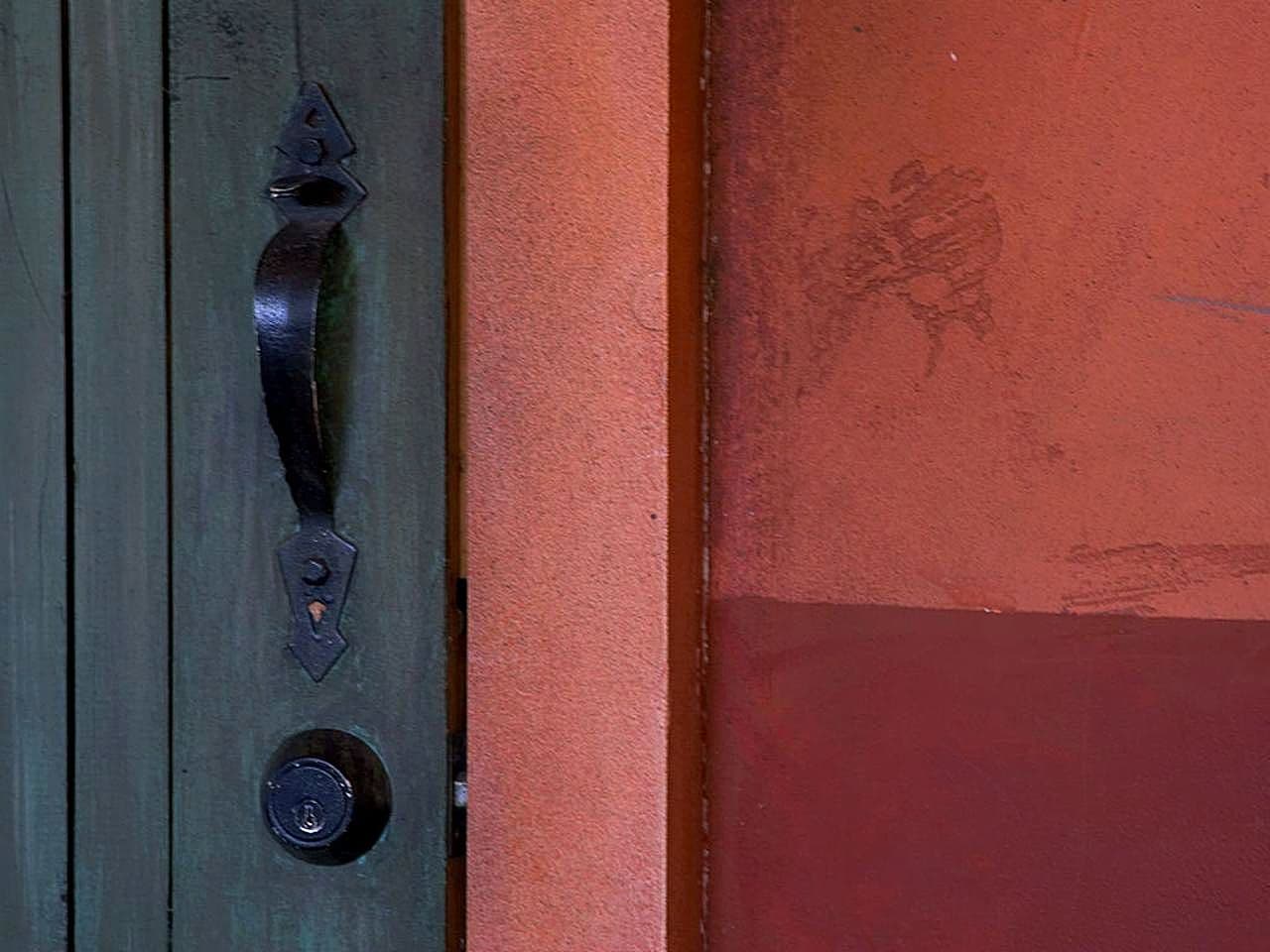 Close-up of a latch bolt and strike plate on a painted timber door